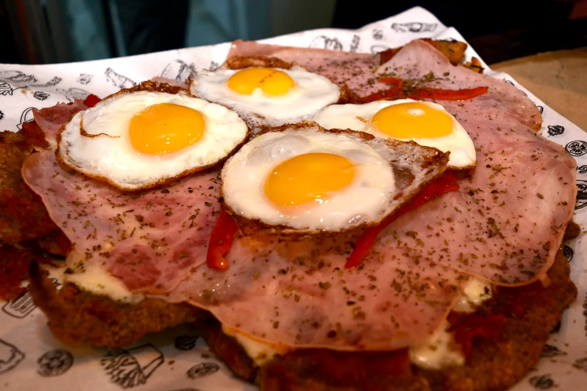 Milanesa a caballo con jamón, morrón y huevos fritos
