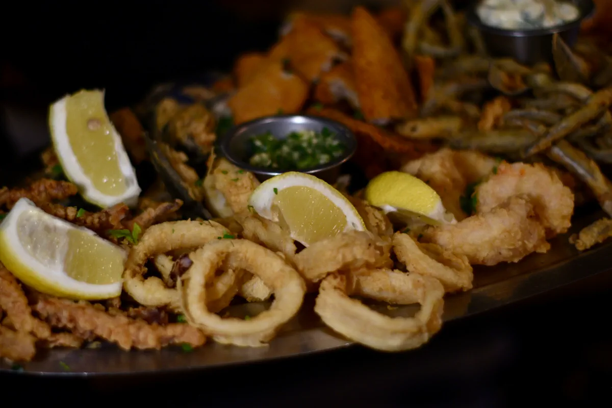 Fuente de frituras de mar: rabas, calamares y langostinos con limón